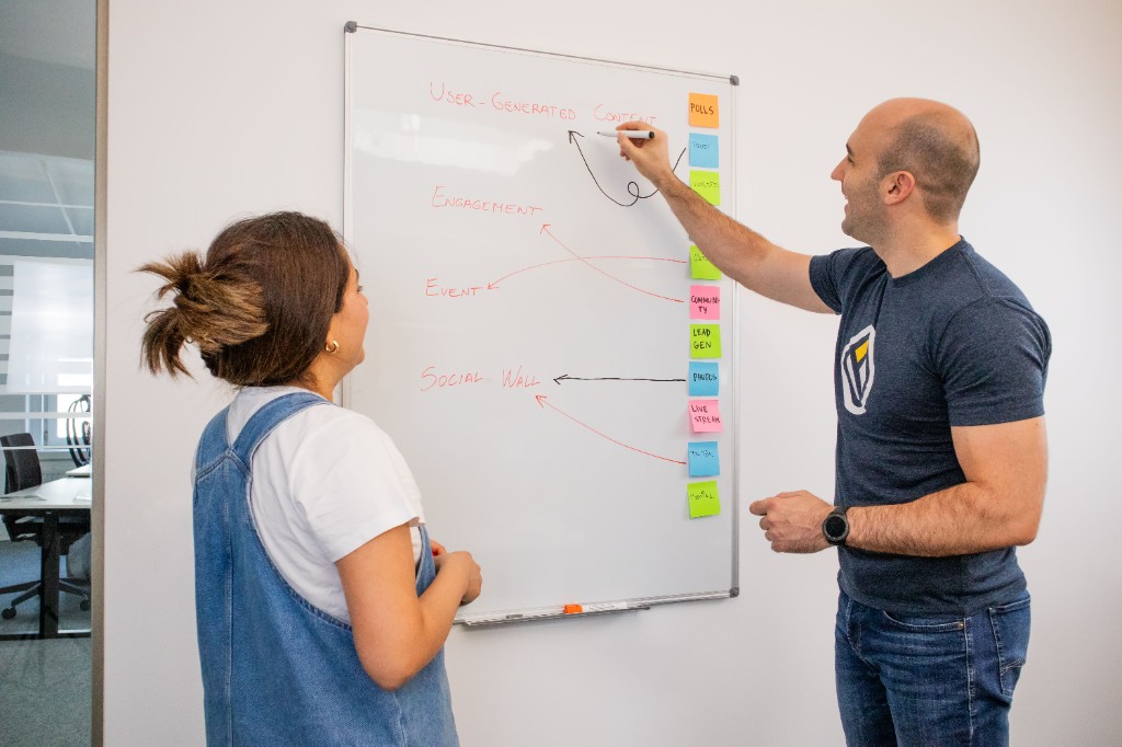 Two people mapping a problem on a whiteboard